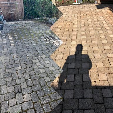 Pflasterfläche mit Schatten einer Person, aufgeteilt in helle und dunkle Bereiche.