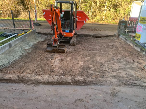 Baumaschine auf unbefestigtem Boden, der für Bauarbeiten vorbereitet wird.